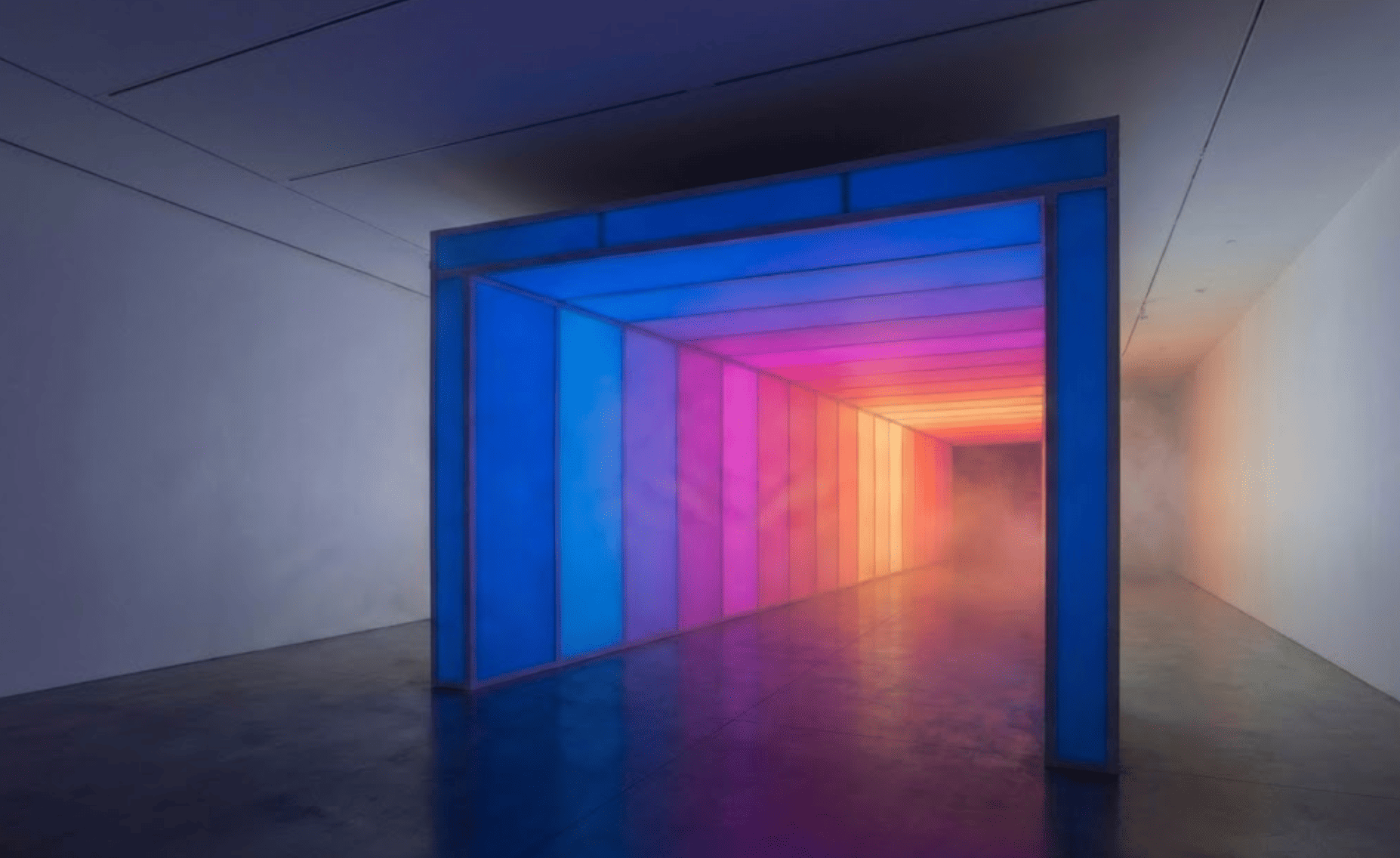 Illuminated corridor installation transitioning from blue to magenta to warm orange light in a gallery space